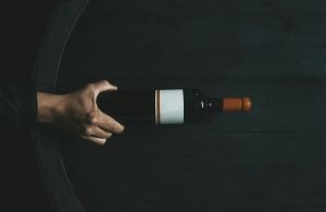 Garrafa de vinho em cima de uma barril