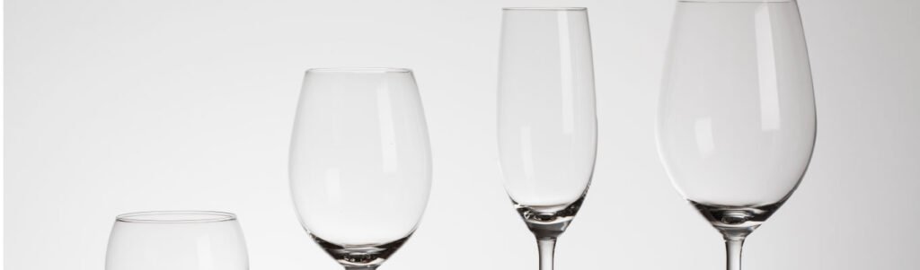 Taça de cristal, vidro ou copo comum com vinho sobre mesa