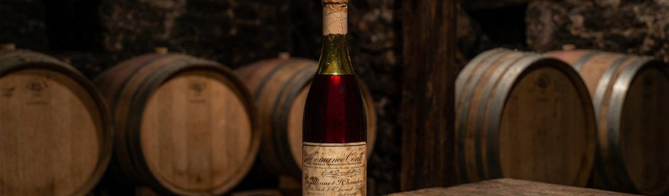 1945 Domaine de la Romanée-Conti wine bottle sitting on a rustic wooden table inside a dark French cellar
