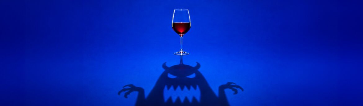 Taça de vinho com sombra em forma de monstro, imagem sobre mitos sobre vinho desmentidos pela ciência.